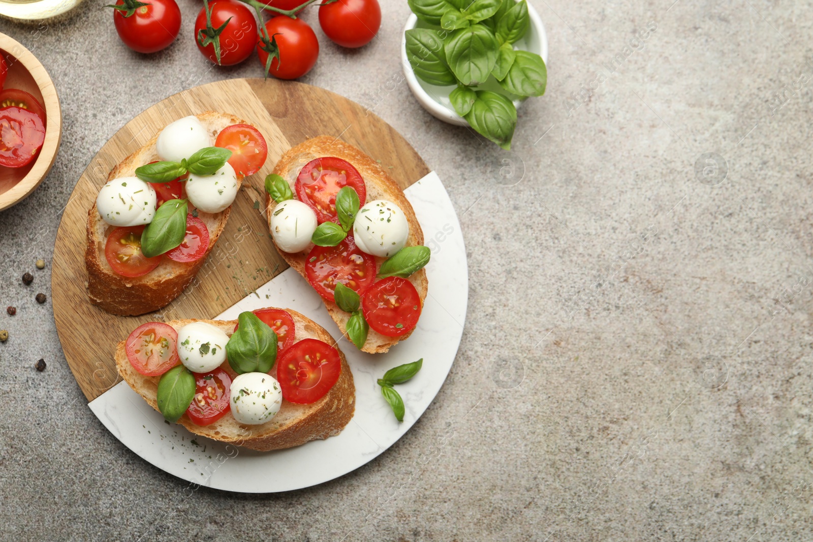 Tasty sandwiches with mozzarella cheese balls, tomato and basil on grey table, flat lay. Space for text Photo of Tasty sandwiches with mozzarella cheese balls, tomato and basil on grey table, flat lay. Space for text