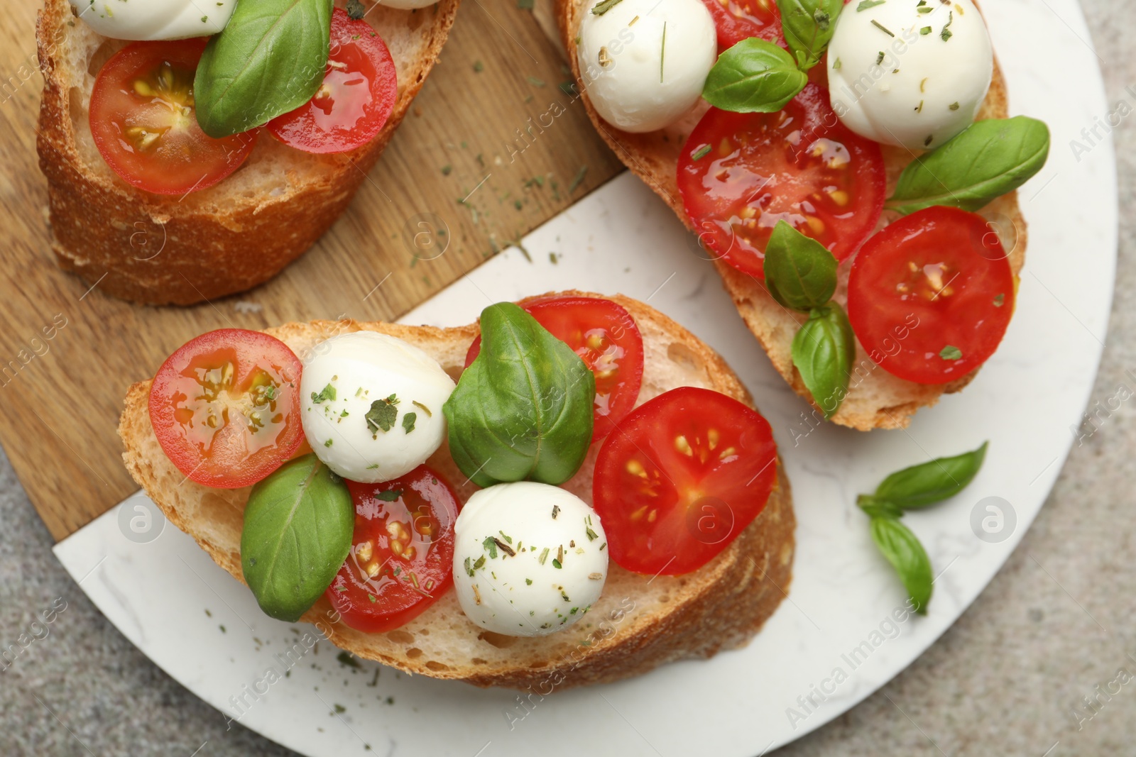 Tasty sandwiches with mozzarella cheese balls, tomato and basil on grey table, top view Photo of Tasty sandwiches with mozzarella cheese balls, tomato and basil on grey table, top view