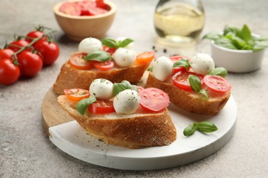 Photo of Tasty sandwiches with mozzarella cheese balls, tomato and basil on grey table, closeup