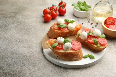 Photo of Tasty sandwiches with mozzarella cheese balls, tomato and basil on grey table. Space for text