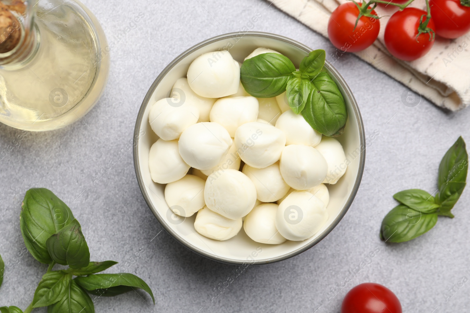 Tasty mozzarella cheese balls, tomatoes and basil on light grey table, flat lay Photo of Tasty mozzarella cheese balls, tomatoes and basil on light grey table, flat lay
