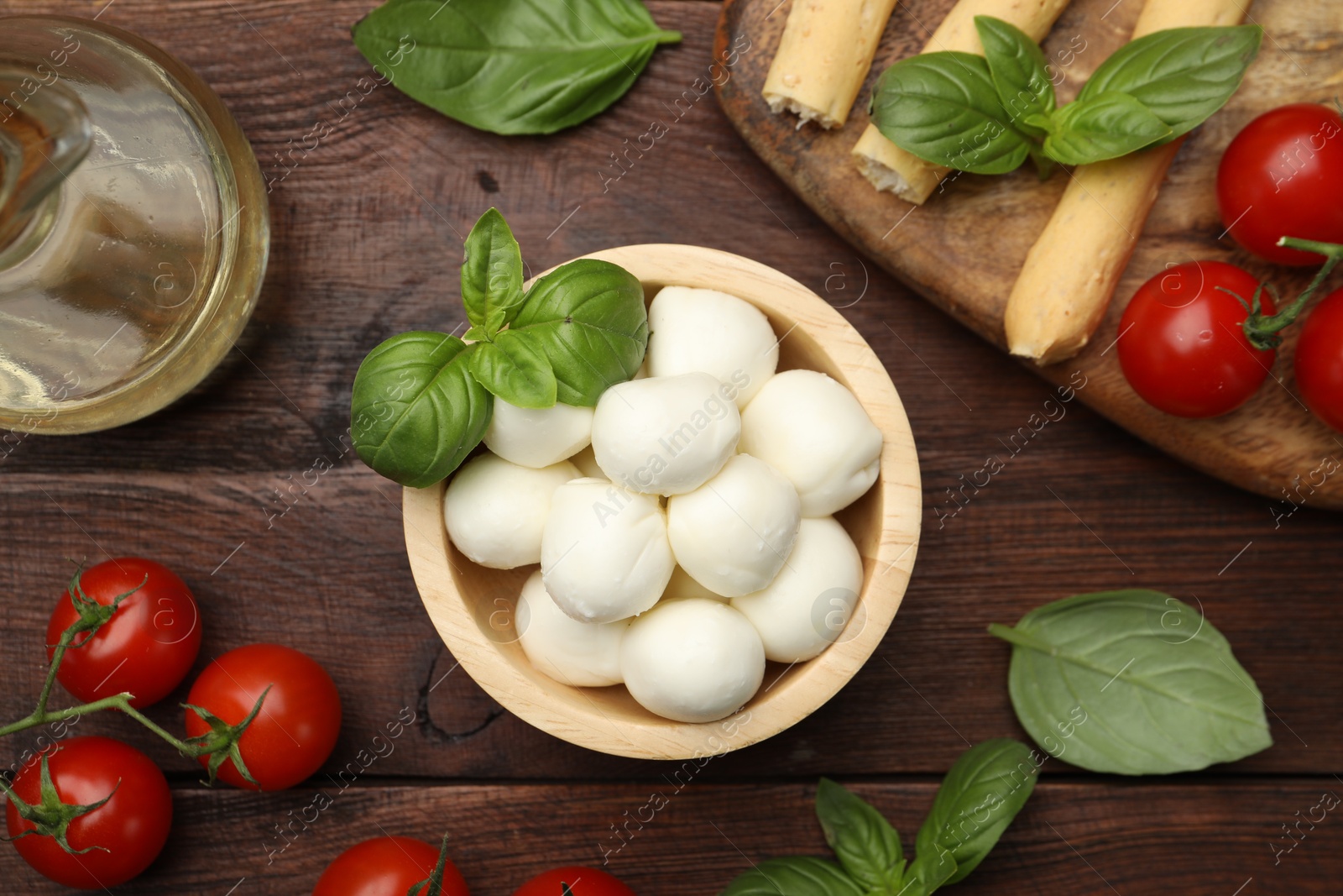 Tasty mozzarella cheese balls, tomatoes and basil on wooden table, flat lay Photo of Tasty mozzarella cheese balls, tomatoes and basil on wooden table, flat lay
