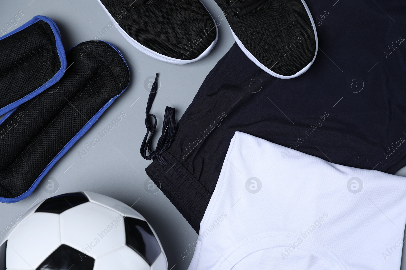 Sportswear, sneakers and soccer ball on grey background, flat lay Photo of Sportswear, sneakers and soccer ball on grey background, flat lay