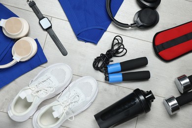 Photo of Flat lay composition with sportswear and headphones on floor