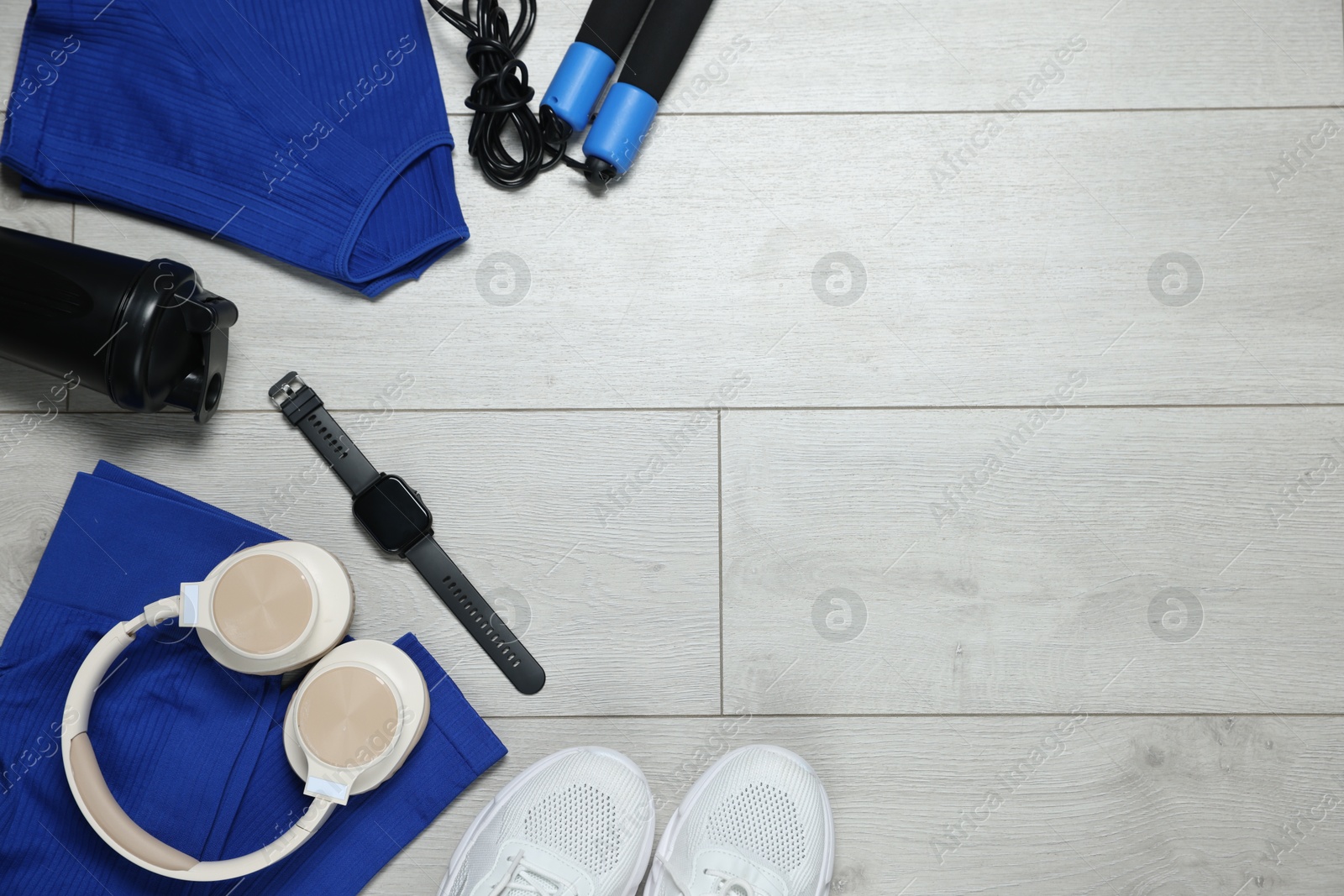 Flat lay composition with sportswear and headphones on floor, space for text Photo of Flat lay composition with sportswear and headphones on floor, space for text