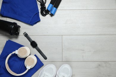 Photo of Flat lay composition with sportswear and headphones on floor, space for text