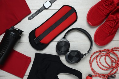 Photo of Flat lay composition with sportswear and headphones on floor