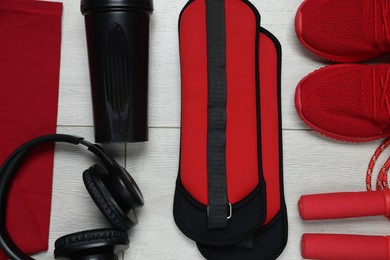 Photo of Flat lay composition with sportswear and headphones on floor