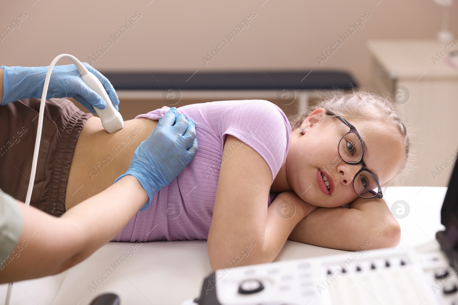 Sonographer conducting girl's renal ultrasound examination in clinic, closeup Photo of Sonographer conducting girl's renal ultrasound examination in clinic, closeup