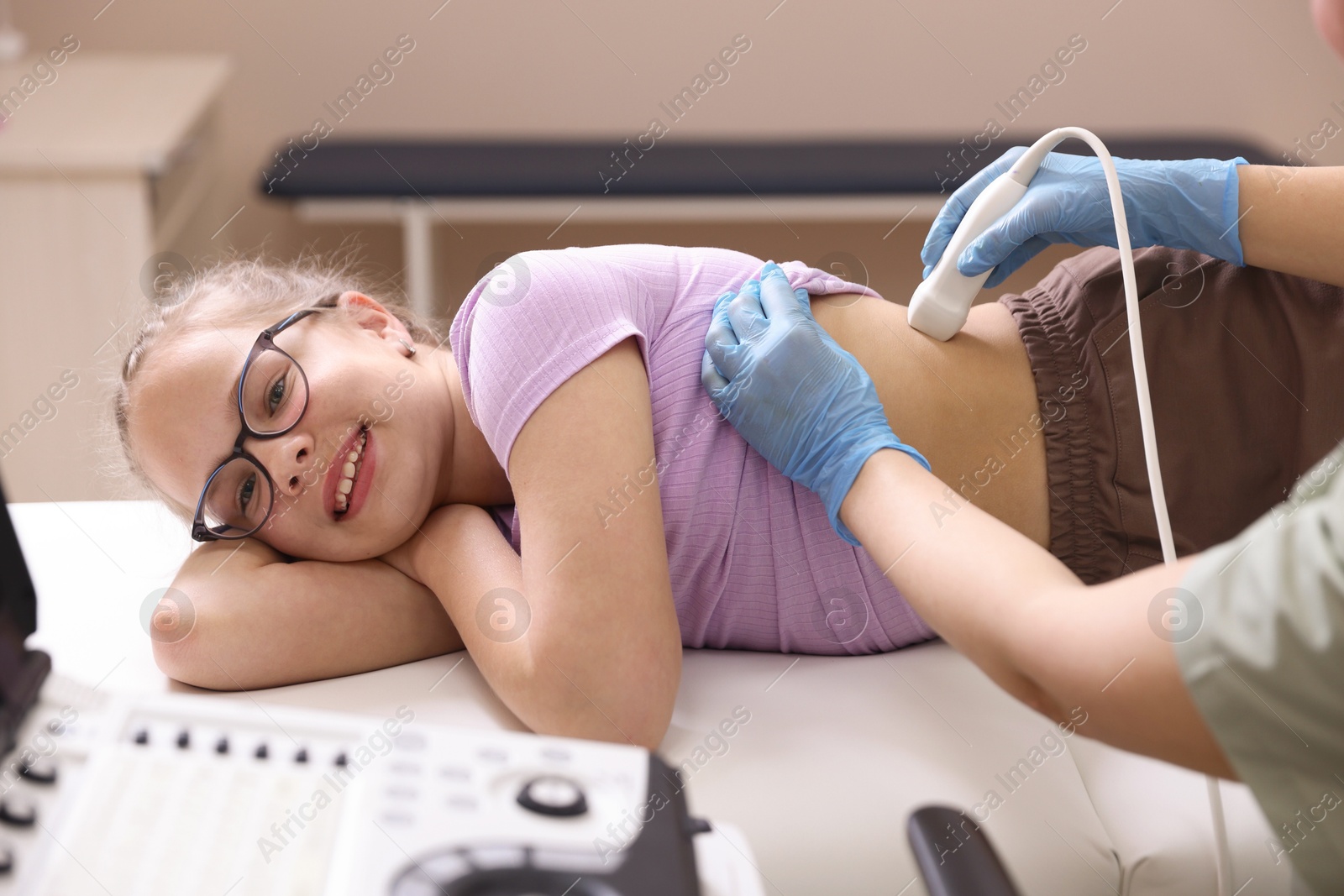 Sonographer conducting girl's renal ultrasound examination in clinic, closeup Photo of Sonographer conducting girl's renal ultrasound examination in clinic, closeup