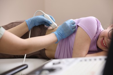 Photo of Sonographer conducting girl's renal ultrasound examination in clinic, closeup