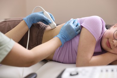 Photo of Sonographer conducting girl's renal ultrasound examination in clinic, closeup