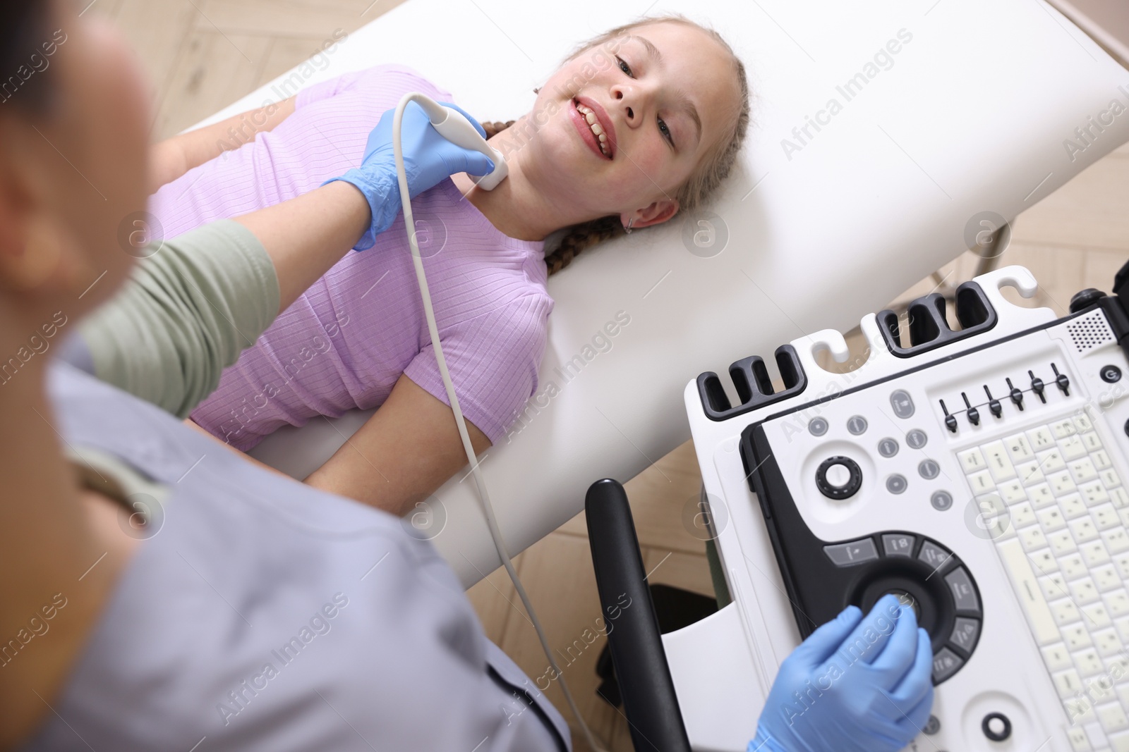 Sonographer conducting girl's thyroid gland ultrasound examination in clinic, above view Photo of Sonographer conducting girl's thyroid gland ultrasound examination in clinic, above view