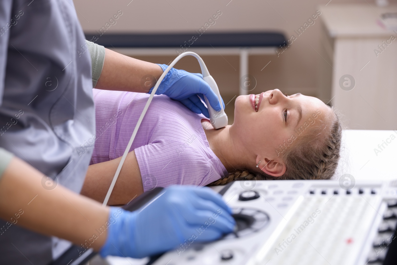 Sonographer conducting girl's thyroid gland ultrasound examination in clinic, closeup Photo of Sonographer conducting girl's thyroid gland ultrasound examination in clinic, closeup