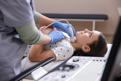 Photo of Sonographer conducting girl's thyroid gland ultrasound examination in clinic, closeup