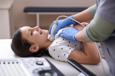 Photo of Sonographer conducting girl's thyroid gland ultrasound examination in clinic, closeup