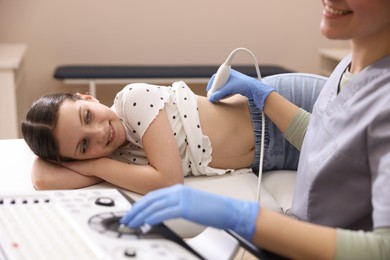 Photo of Sonographer conducting girl's renal ultrasound examination in clinic, closeup