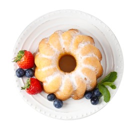 Photo of Tasty Bundt cake with powdered sugar and berries isolated on white, top view