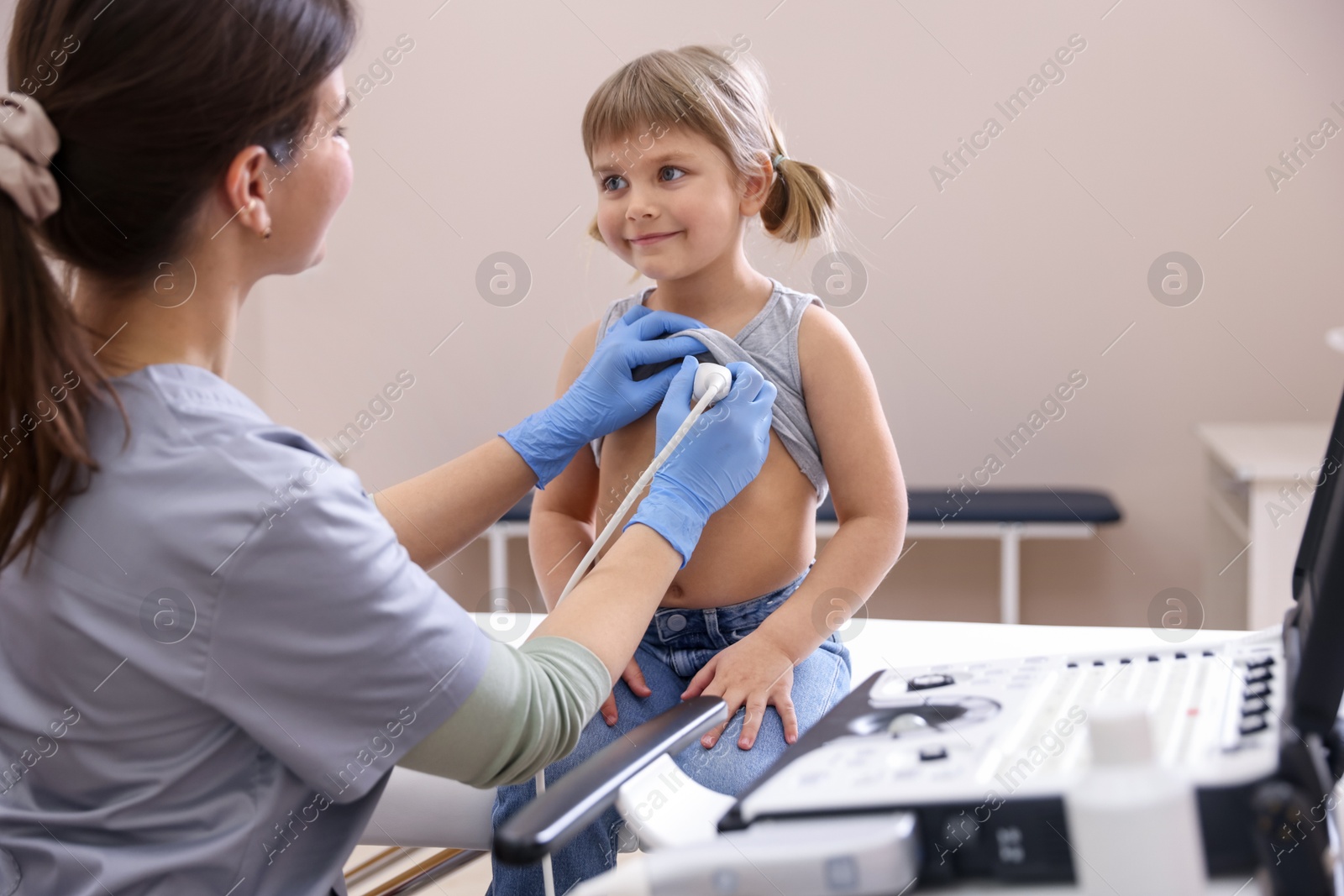 Sonographer conducting ultrasound examination of little girl's heart in clinic Photo of Sonographer conducting ultrasound examination of little girl's heart in clinic