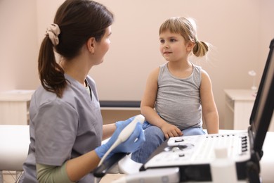 Photo of Sonographer conducting little girl's ultrasound examination in clinic
