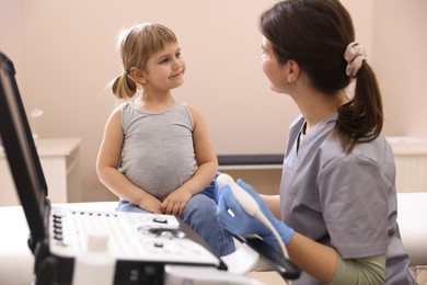 Photo of Sonographer conducting little girl's ultrasound examination in clinic