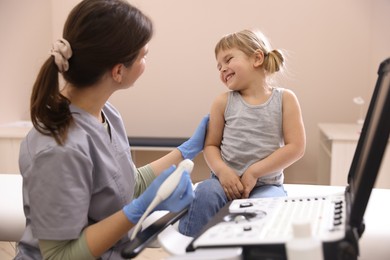 Photo of Sonographer conducting little girl's ultrasound examination in clinic