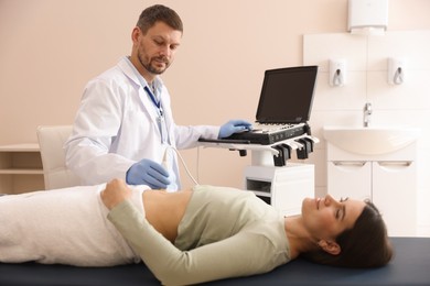 Photo of Sonographer conducting woman's abdominal ultrasound examination in clinic