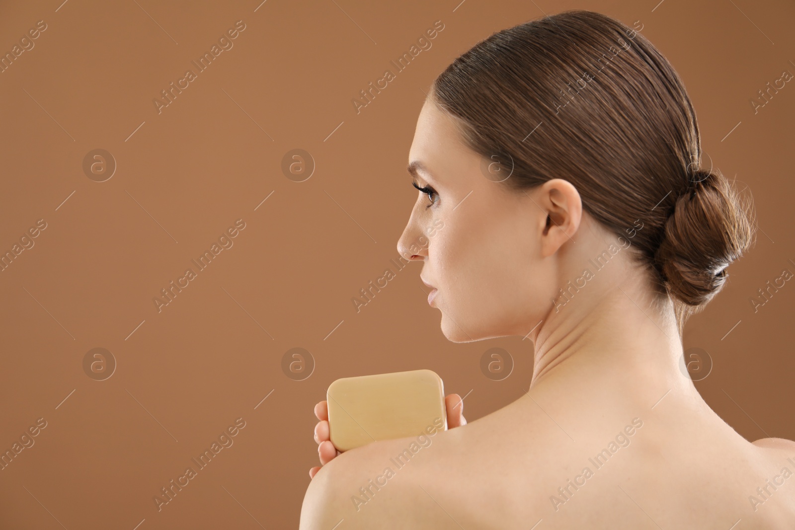 Woman with soap bar on brown background. Space for text Photo of Woman with soap bar on brown background. Space for text