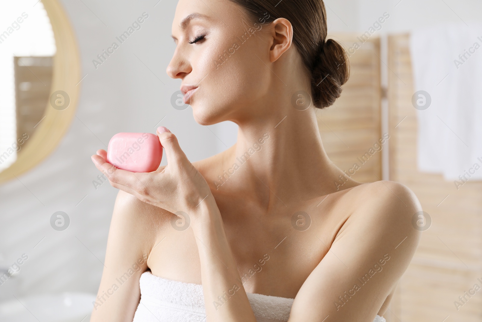 Beautiful woman with soap bar in bathroom, closeup Photo of Beautiful woman with soap bar in bathroom, closeup