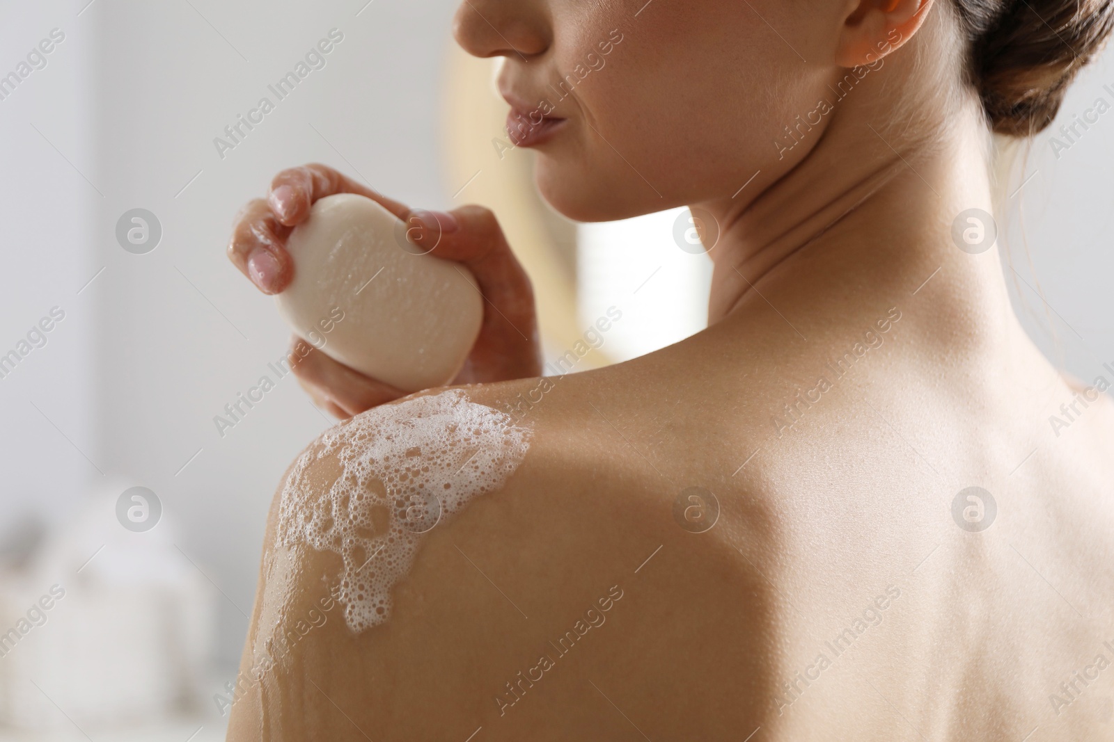 Woman washing body with soap bar indoors, closeup Photo of Woman washing body with soap bar indoors, closeup