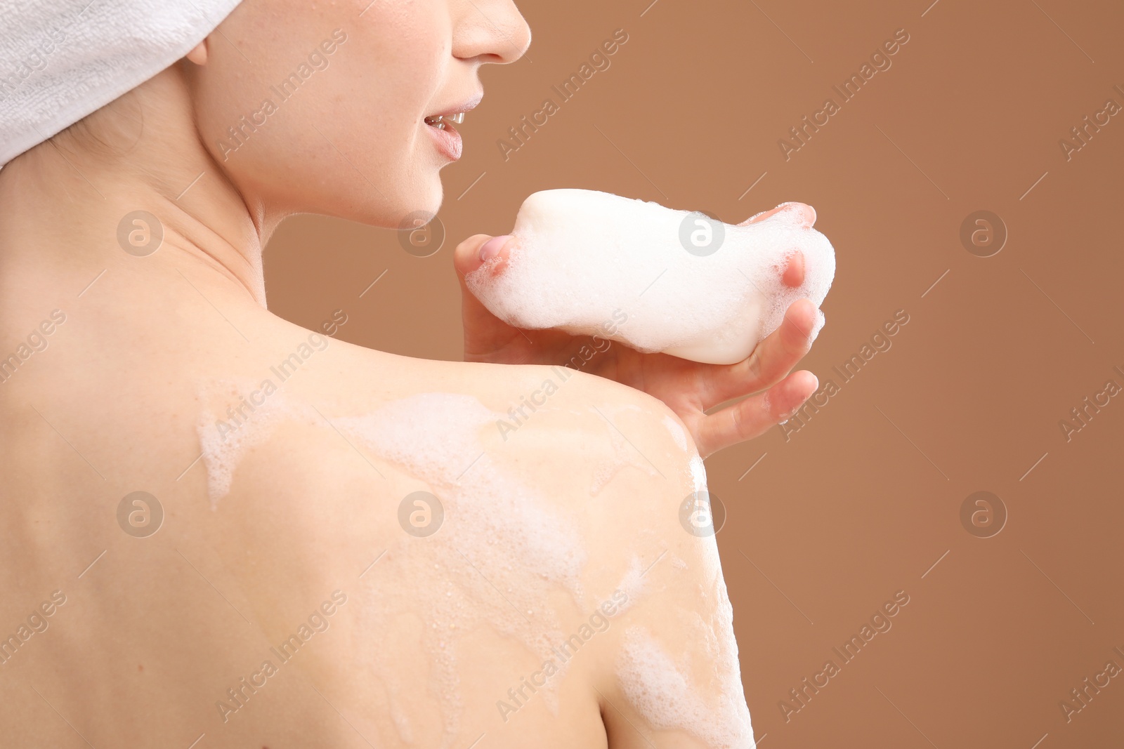 Woman with soap bar on brown background, closeup Photo of Woman with soap bar on brown background, closeup