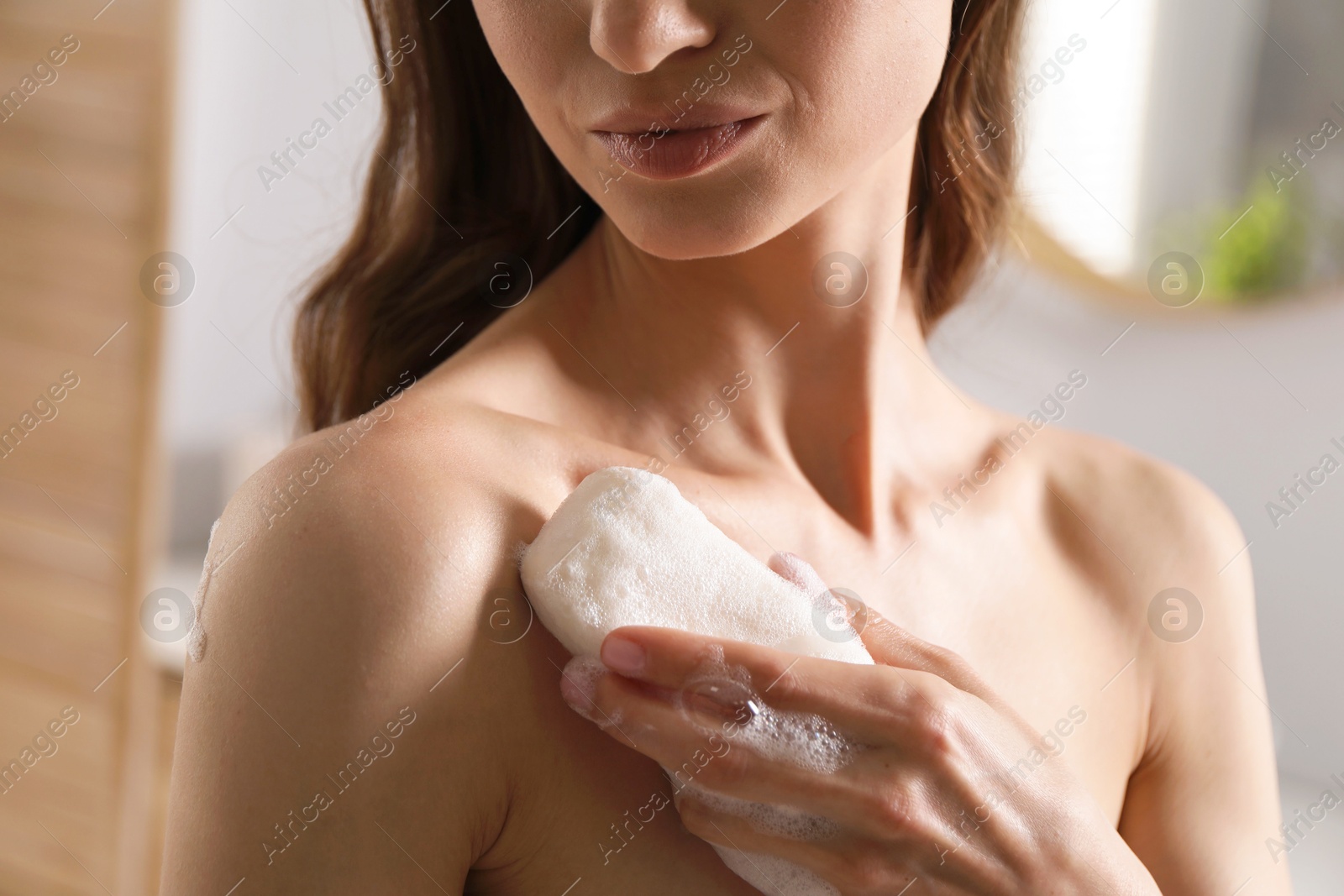 Woman washing body with soap bar in bathroom, closeup Photo of Woman washing body with soap bar in bathroom, closeup