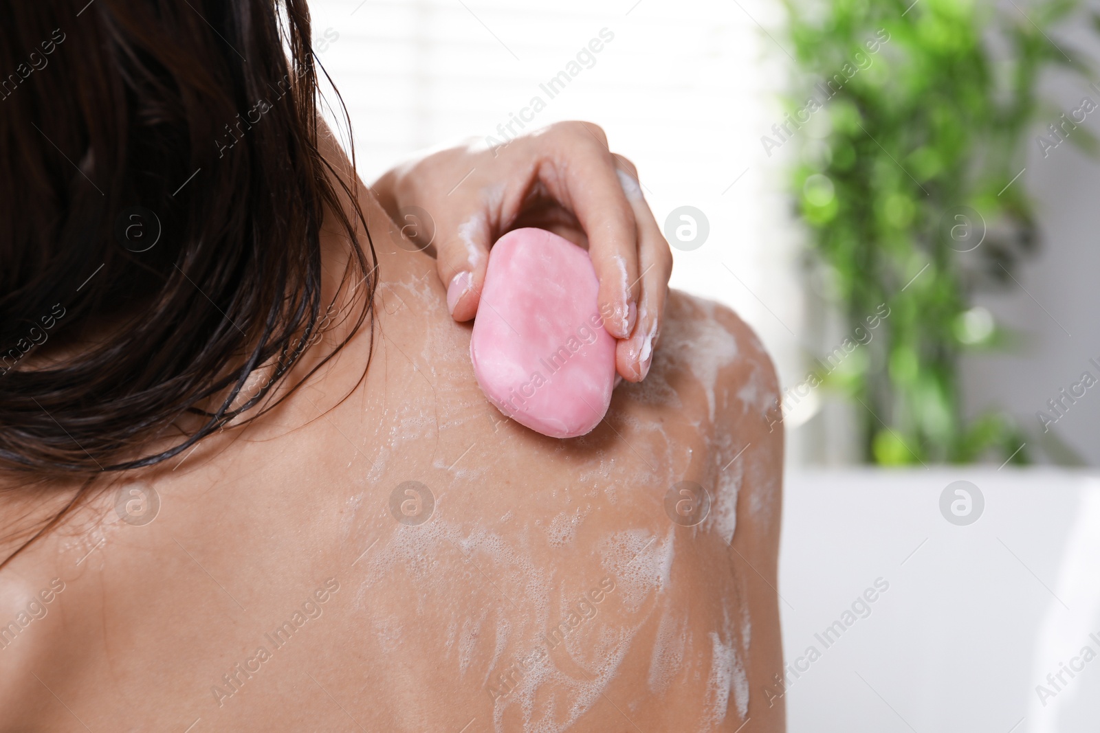 Woman washing body with soap bar in bathroom, closeup Photo of Woman washing body with soap bar in bathroom, closeup