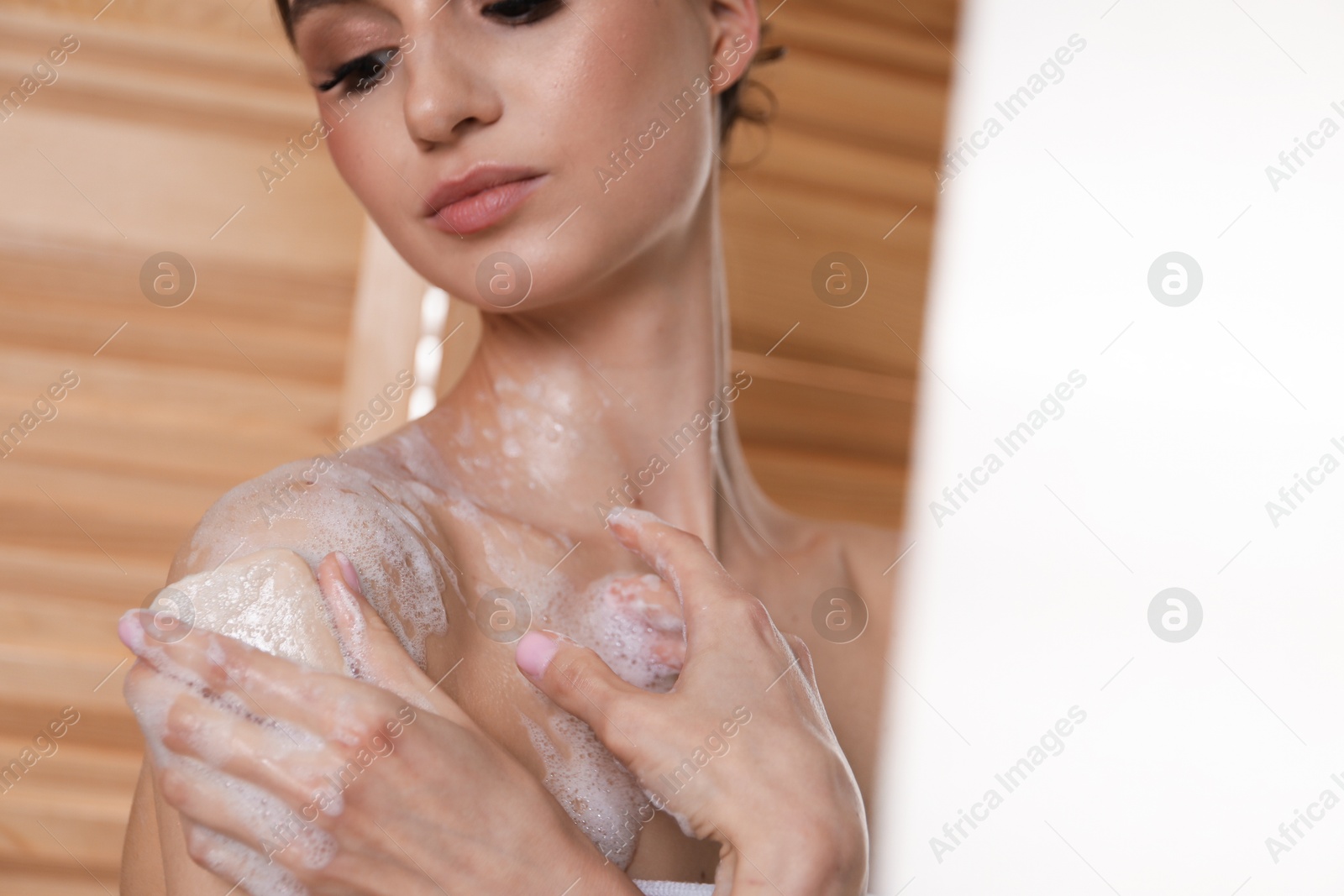 Woman washing body with soap bar indoors, closeup Photo of Woman washing body with soap bar indoors, closeup