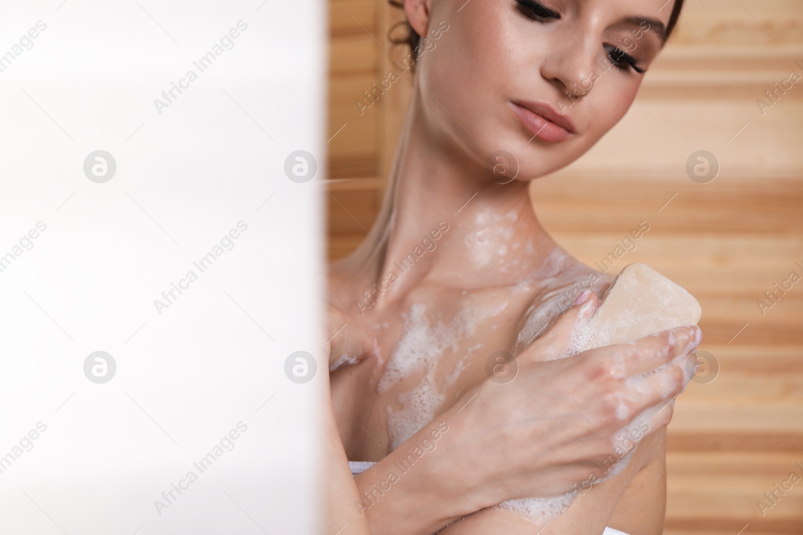 Woman washing body with soap bar indoors, closeup. Space for text Photo of Woman washing body with soap bar indoors, closeup. Space for text