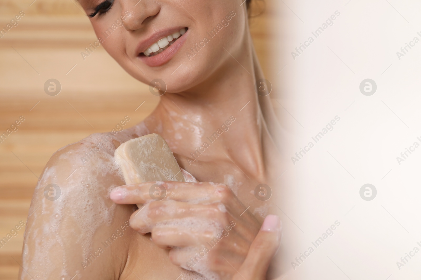 Smiling woman washing body with soap bar in bathroom, closeup Photo of Smiling woman washing body with soap bar in bathroom, closeup