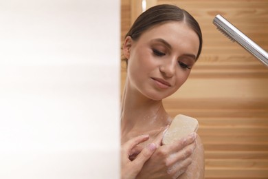 Photo of Woman washing body with soap bar indoors. Space for text