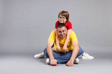 Photo of Father and his son on grey background, space for text