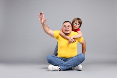 Photo of Father and his son on grey background, space for text