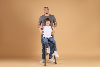 Photo of Father and his son on beige background
