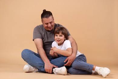 Photo of Father and his son on beige background