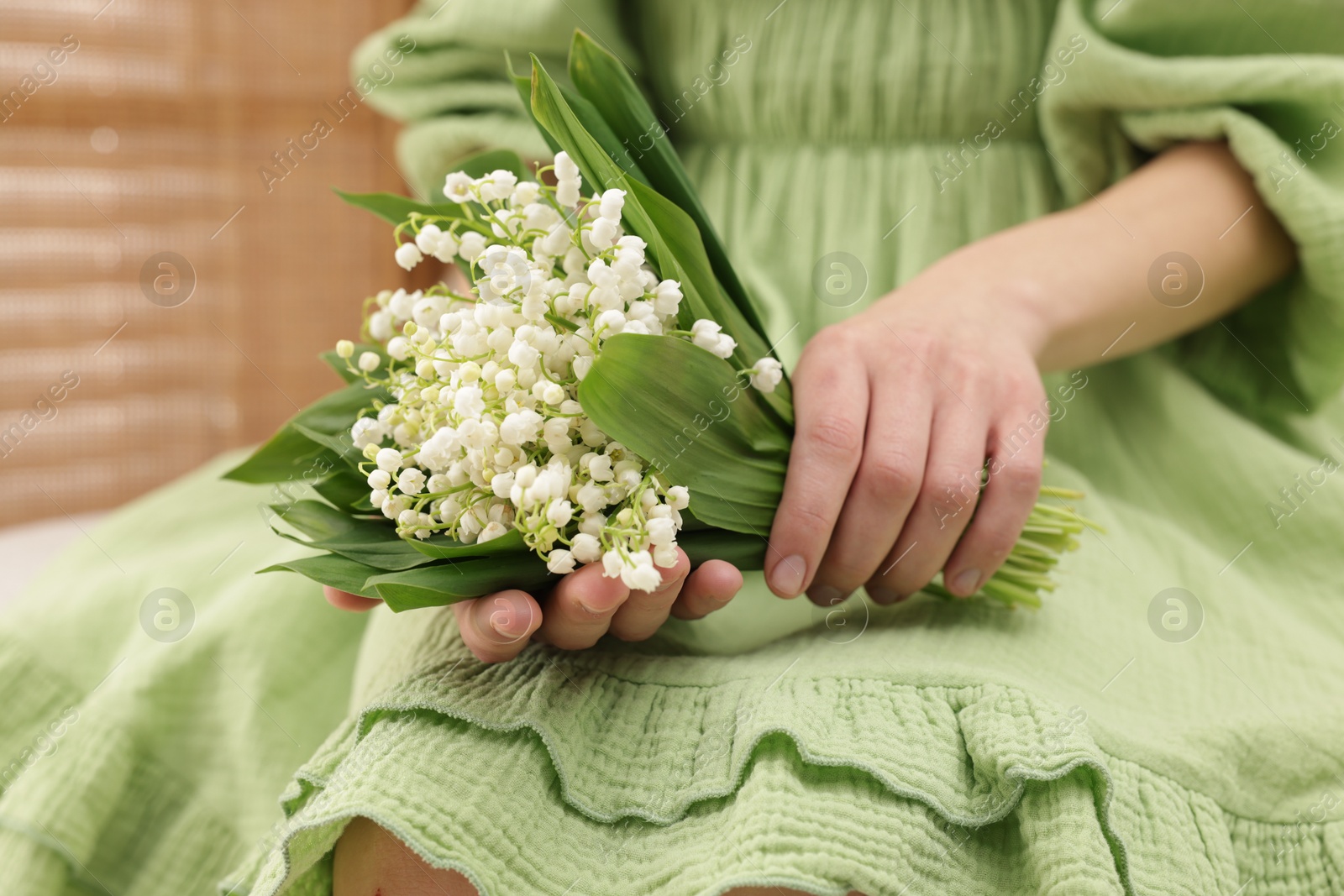 Woman with beautiful lilies of the valley flowers indoors, closeup Photo of Woman with beautiful lilies of the valley flowers indoors, closeup