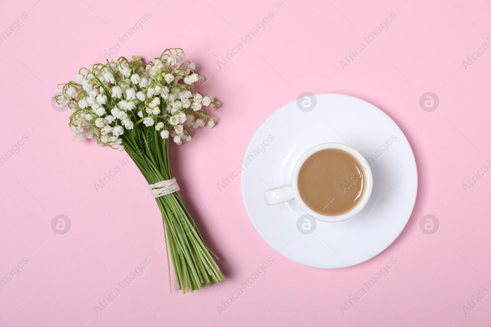 Beautiful lily-of-the-valley flowers and coffee on light pink background, top view Photo of Beautiful lily-of-the-valley flowers and coffee on light pink background, top view