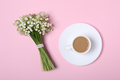 Photo of Beautiful lily-of-the-valley flowers and coffee on light pink background, top view