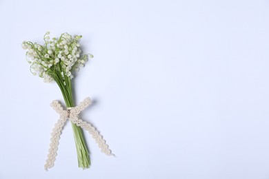 Photo of Beautiful lily-of-the-valley flowers on white background, top view. Space for text