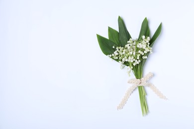 Photo of Beautiful lily-of-the-valley flowers on white background, top view. Space for text