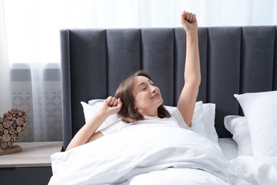 Photo of Beautiful woman stretching in bed at home
