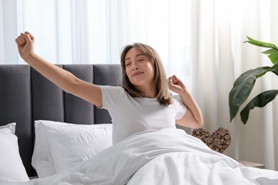 Photo of Beautiful woman stretching in bed at home