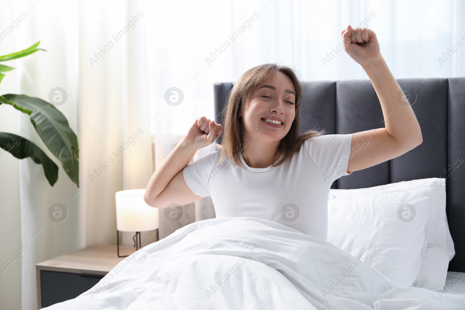 Beautiful woman stretching in bed at home Photo of Beautiful woman stretching in bed at home