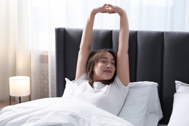 Photo of Beautiful woman stretching in bed at home